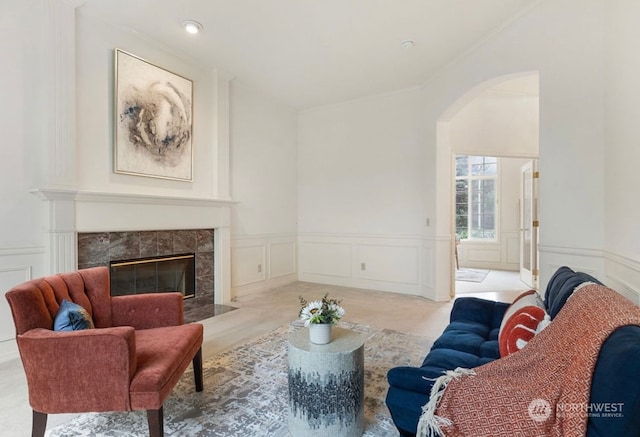 living room featuring a fireplace, crown molding, and light hardwood / wood-style flooring