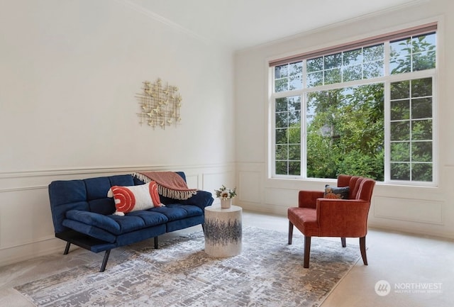 living area featuring ornamental molding and carpet floors