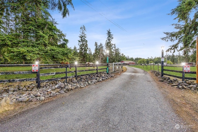 view of road featuring a rural view and a gate