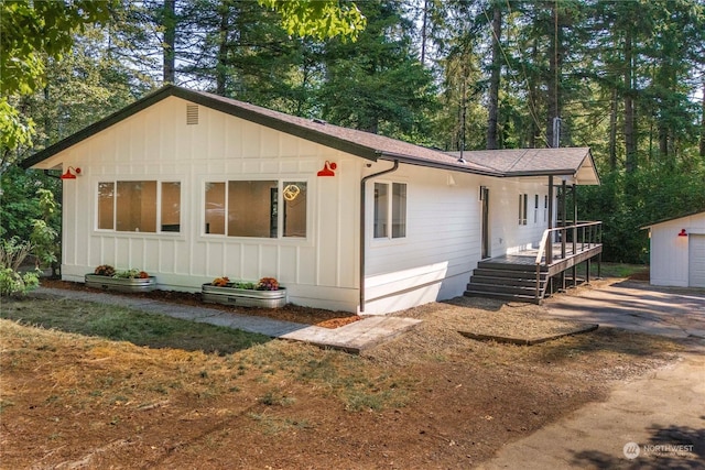 view of front of home featuring a deck and an outdoor structure