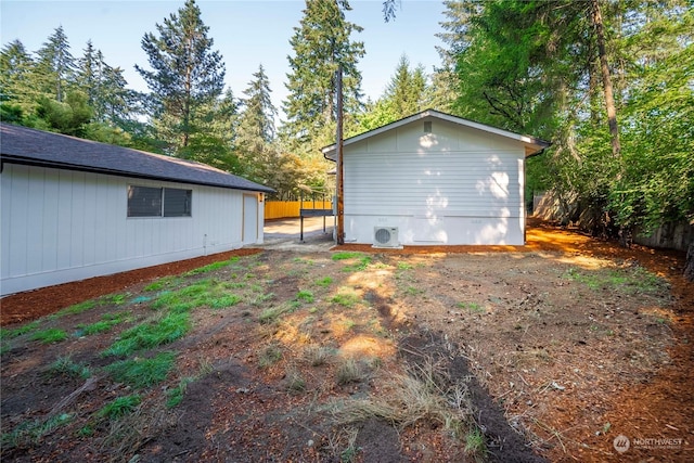 view of side of home featuring ac unit and fence