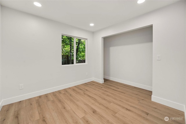 unfurnished bedroom featuring baseboards, light wood-type flooring, and recessed lighting