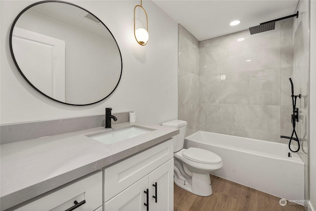 full bathroom with toilet, shower / washtub combination, wood finished floors, and vanity