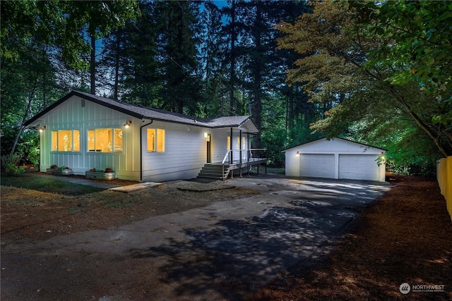 ranch-style home featuring a garage, board and batten siding, and an outbuilding