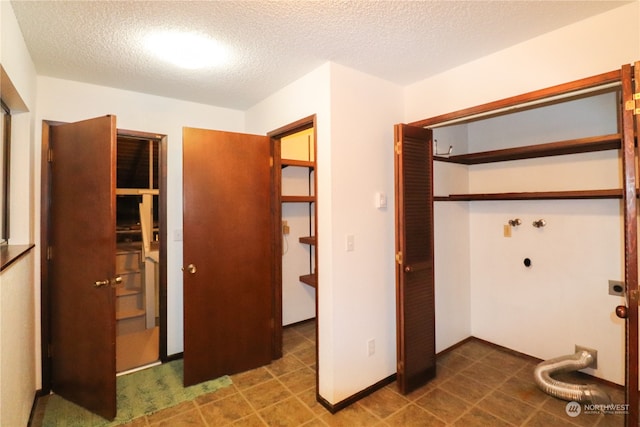 interior space with a textured ceiling, electric dryer hookup, and hookup for a washing machine