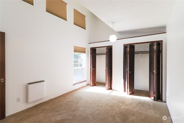 unfurnished bedroom featuring carpet flooring and multiple closets