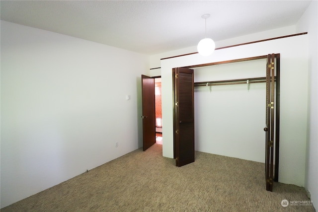 unfurnished bedroom featuring carpet and a closet