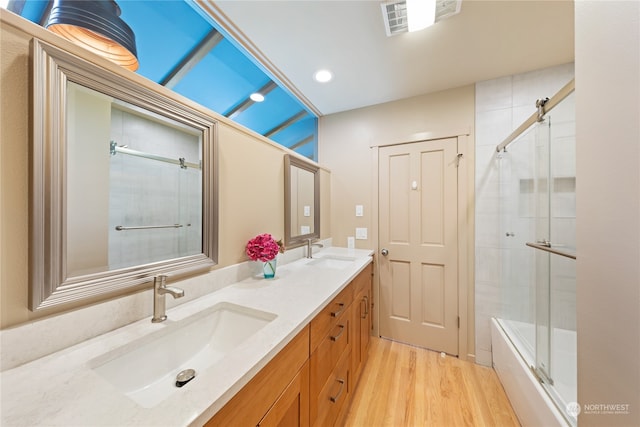 bathroom with shower / bath combination with glass door, vanity, and wood-type flooring