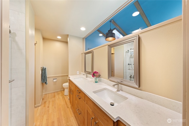 bathroom featuring walk in shower, vanity, toilet, and hardwood / wood-style flooring