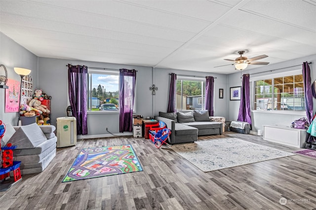 living area with ceiling fan, baseboards, and wood finished floors