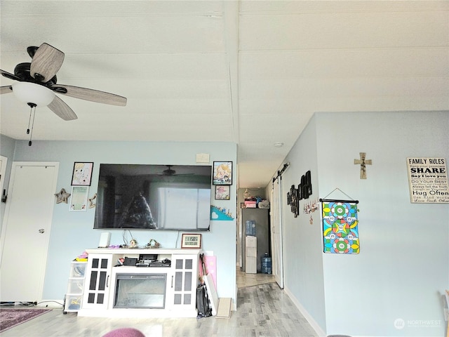 living area featuring ceiling fan, wood finished floors, and baseboards