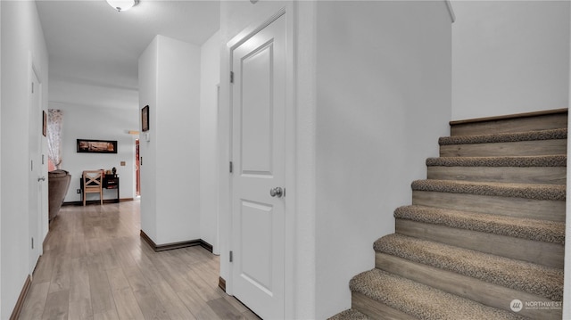 stairs with baseboards and wood finished floors