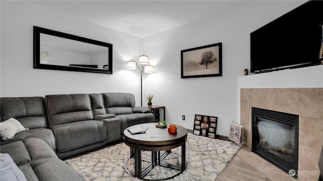 living room with baseboards and a tile fireplace