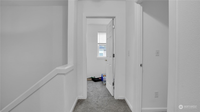 hallway featuring light colored carpet