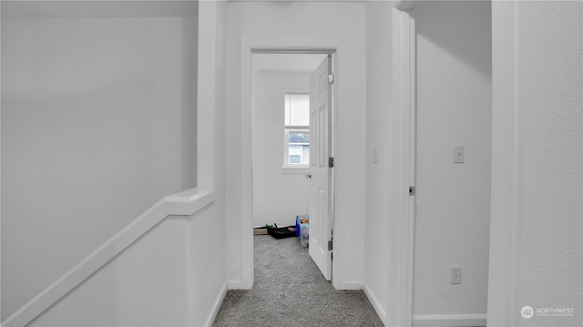 corridor featuring carpet flooring and baseboards