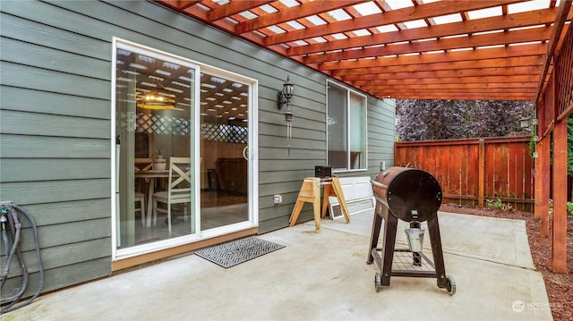 view of patio featuring a grill, a pergola, and fence