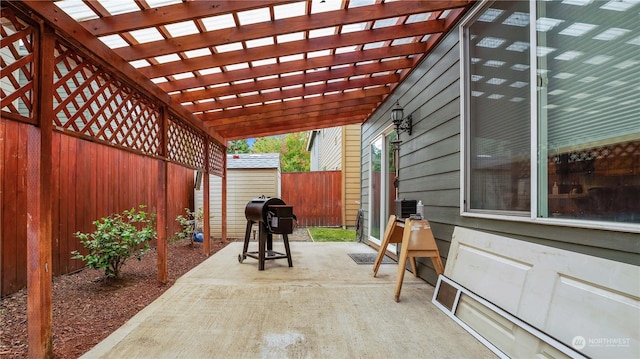 view of patio / terrace featuring an outbuilding, a shed, a fenced backyard, a pergola, and a grill