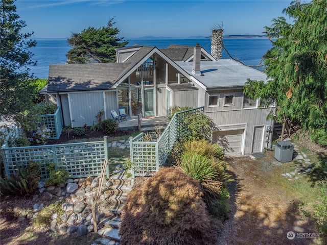 view of front of property with a water view, a garage, and cooling unit