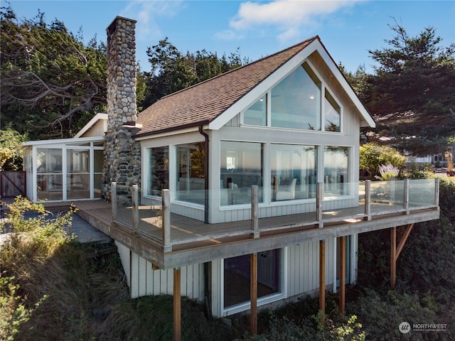 back of property with a sunroom and a wooden deck