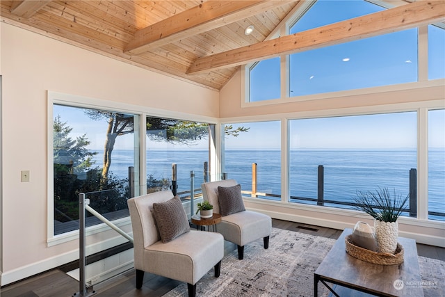 sunroom with a water view, a healthy amount of sunlight, and vaulted ceiling with beams