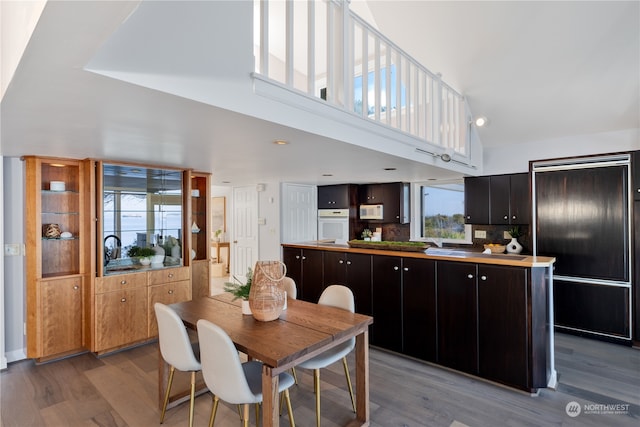 dining area featuring a high ceiling, plenty of natural light, and light hardwood / wood-style flooring