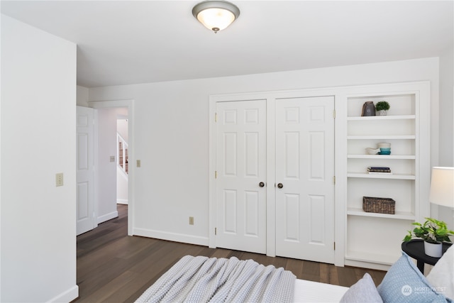 bedroom with dark wood-type flooring and a closet