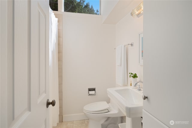 bathroom with toilet, curtained shower, and tile patterned floors