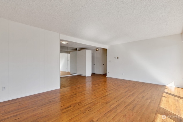 spare room with a textured ceiling and hardwood / wood-style floors