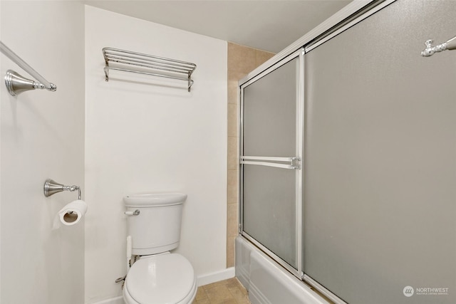 bathroom with combined bath / shower with glass door, toilet, and tile patterned flooring