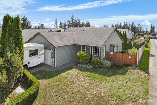 view of front of house featuring driveway, roof with shingles, an attached garage, fence, and a front lawn