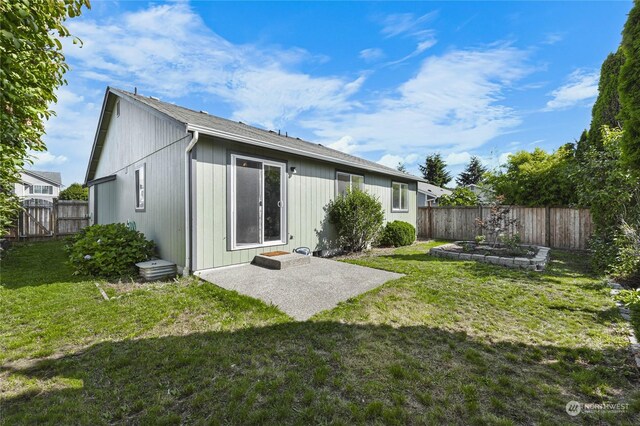 back of property featuring a fenced backyard, a lawn, and a patio