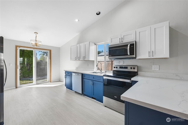 kitchen with appliances with stainless steel finishes, a chandelier, a wealth of natural light, and sink