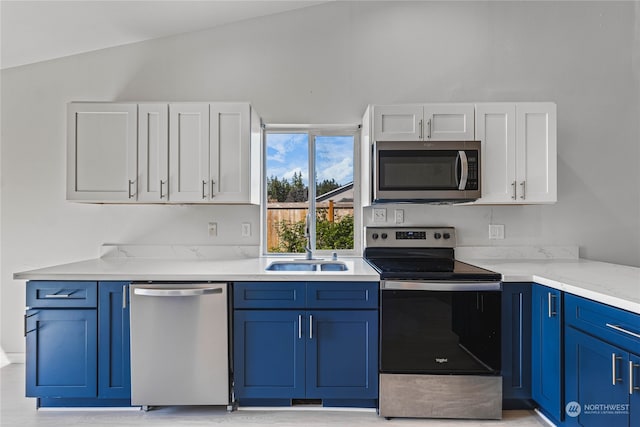 kitchen with light stone counters, stainless steel appliances, sink, lofted ceiling, and blue cabinets