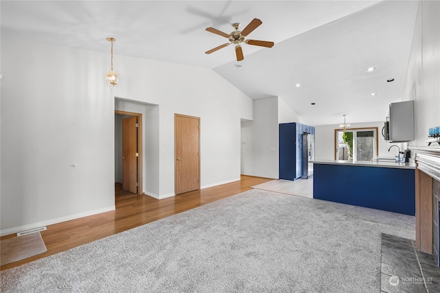 interior space featuring light hardwood / wood-style floors, kitchen peninsula, sink, high vaulted ceiling, and ceiling fan