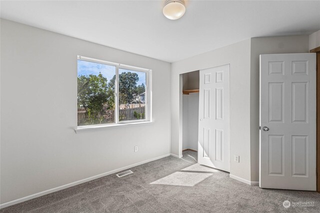 unfurnished bedroom with baseboards, a closet, visible vents, and carpet flooring