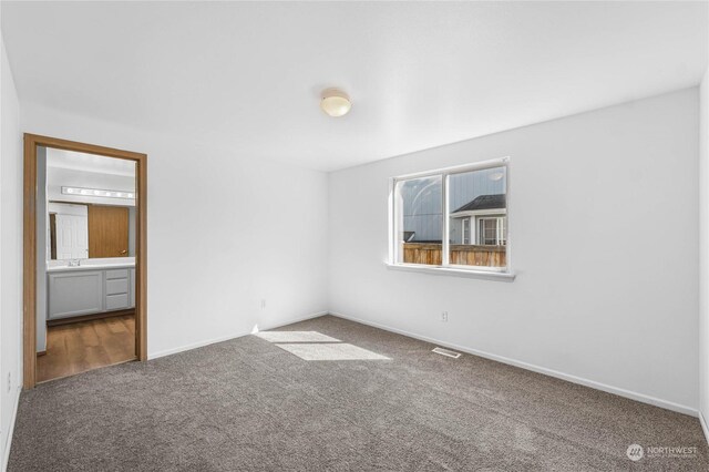 unfurnished bedroom featuring carpet flooring, visible vents, and baseboards