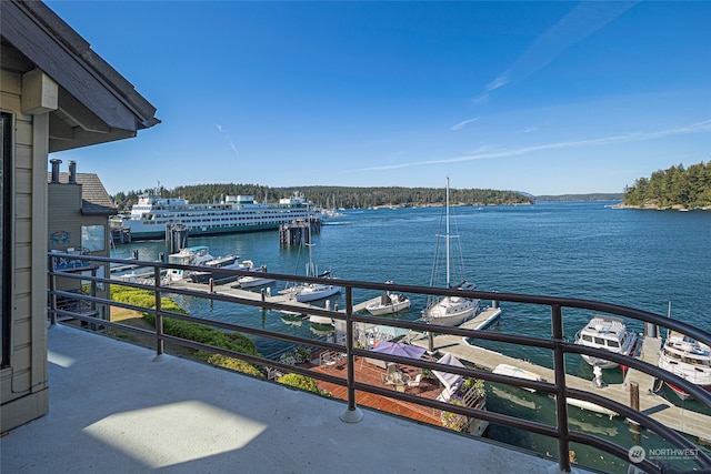 view of dock with a balcony and a water view