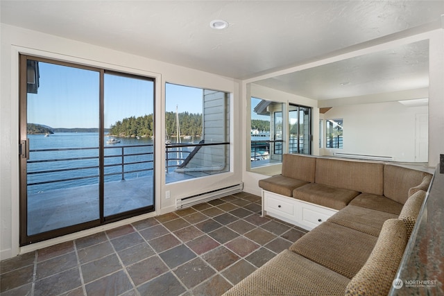 unfurnished living room with a water view and a baseboard heating unit