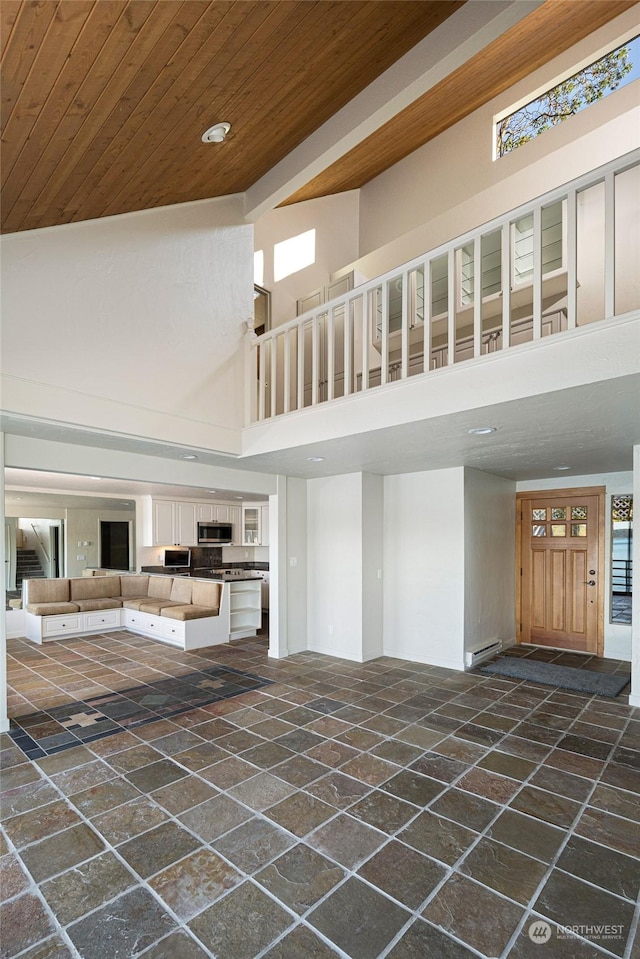 241 Warbass Way Unit A303, Friday Harbor, WA 98250 - unfurnished living room featuring stone tile floors, a high ceiling, a baseboard heating unit, wood ceiling, and recessed lighting