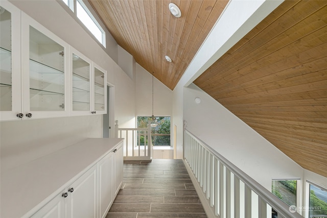 hall with wood ceiling, dark hardwood / wood-style floors, and lofted ceiling