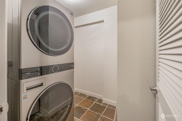 241 Warbass Way Unit A303, Friday Harbor, WA 98250 - laundry room with estacked washer and dryer, stone tile floors, and a textured ceiling
