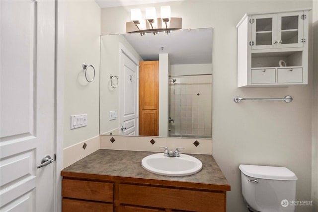 bathroom with vanity, toilet, and a tile shower