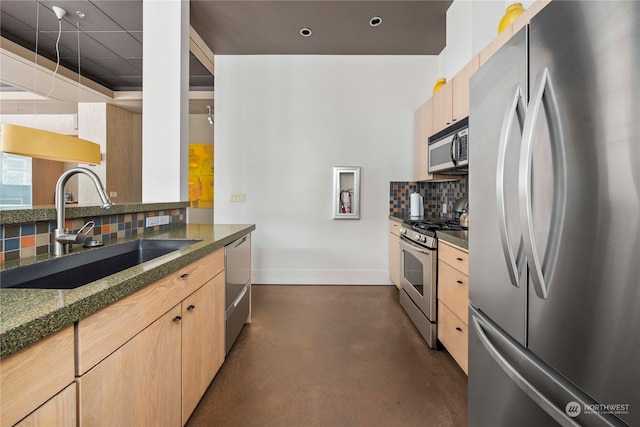 kitchen featuring appliances with stainless steel finishes, backsplash, light brown cabinetry, and sink