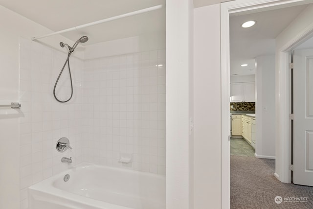 bathroom with tiled shower / bath combo, vanity, and decorative backsplash