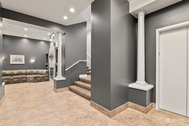 interior space with tile patterned flooring, vaulted ceiling, and ornate columns