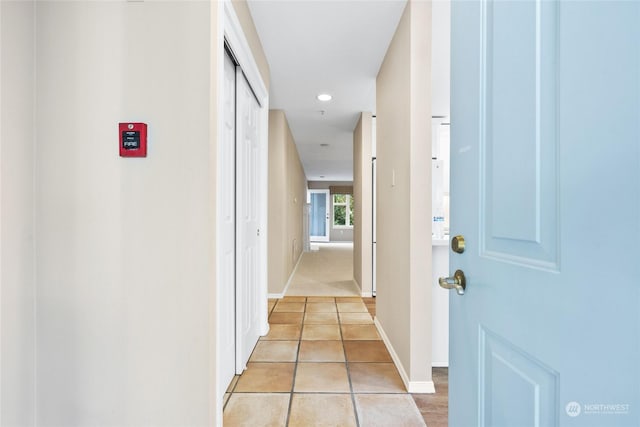 hall featuring light tile patterned floors, recessed lighting, and baseboards