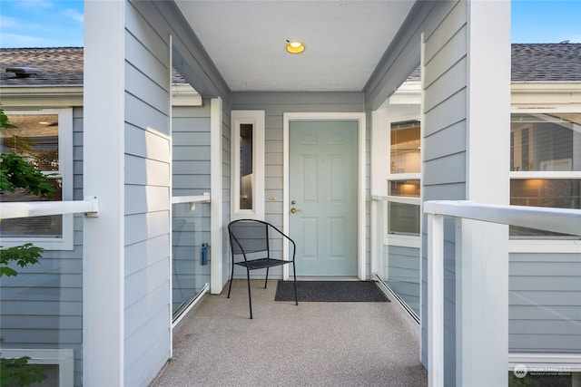 doorway to property featuring a shingled roof