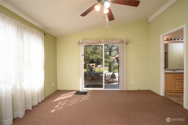 empty room featuring lofted ceiling, carpet flooring, and ceiling fan