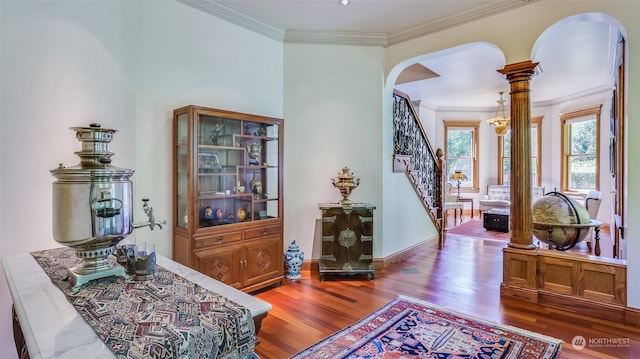 living area with ornamental molding, hardwood / wood-style floors, and decorative columns