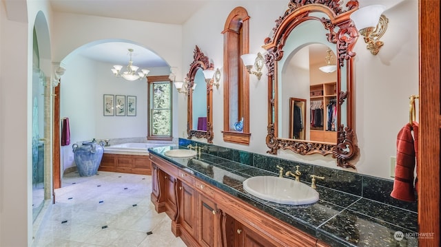 bathroom featuring tile patterned flooring, a tub to relax in, a chandelier, and vanity